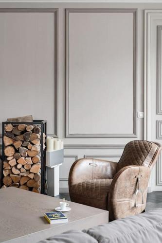 - un salon avec un fauteuil en cuir et une table dans l'établissement Resplendent Haussmann Design 100m2 - 2 BR, à Paris