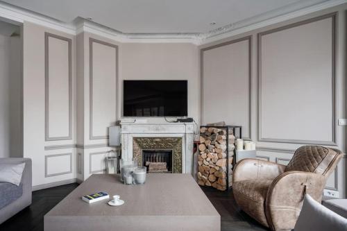 - un salon avec une cheminée, un canapé et une table dans l'établissement Resplendent Haussmann Design 100m2 - 2 BR, à Paris