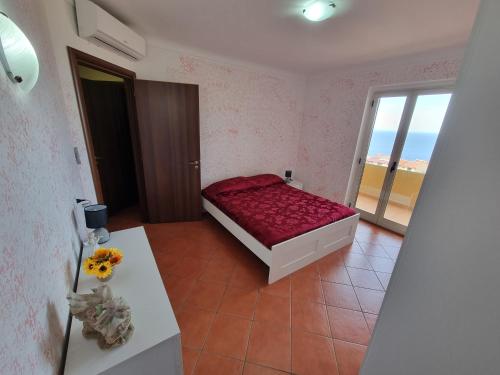 a bedroom with a bed and a table and a window at Casa Vacanze Matteotti di Scilla in Scilla