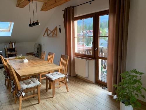 a dining room with a wooden table and chairs at Willa z Widokiem in Szklarska Poręba