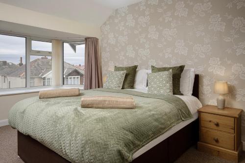 a bedroom with a large bed with a window at Arnside - Spacious 10-Bedroom Seaside Cottage in Blackpool