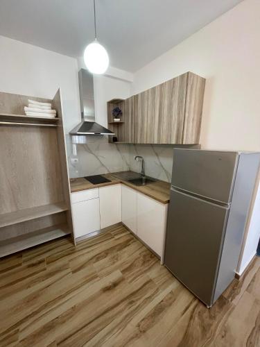 a kitchen with a stainless steel refrigerator and wooden floors at Julies Vila in Ksamil