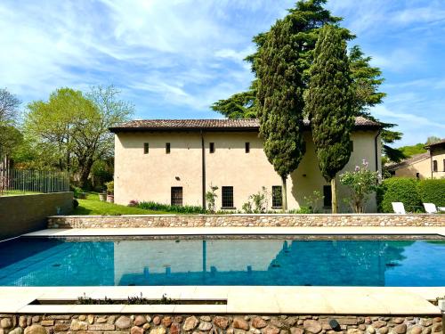 a house with a swimming pool in front of a house at Solimago Dimora Storica in Solferino