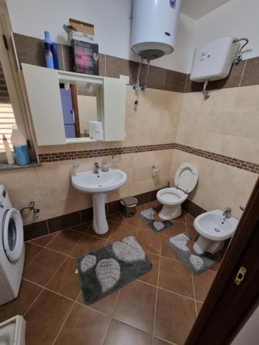a bathroom with two sinks and a toilet and a mirror at Casa Vacanze Matteotti di Scilla in Scilla