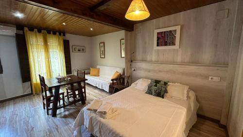 a bedroom with a bed and a table and a desk at Alojamiento Turístico la Moneda de Huecar in Cuenca