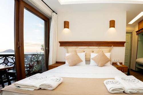 a bedroom with a bed with two towels on it at west coast boutique hotel in Bodrum City