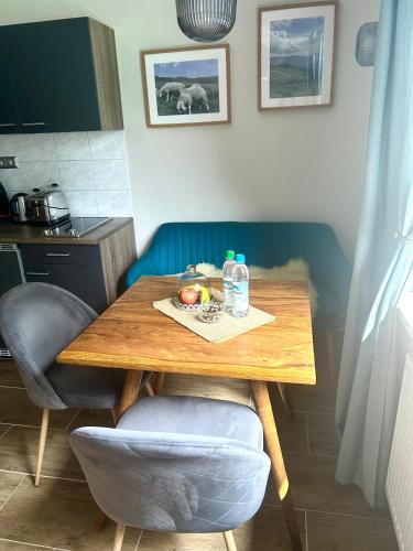 a table with a bowl of fruit and a bottle of water at Großes Apartment mit Terrasse und Garten in Oberhaching