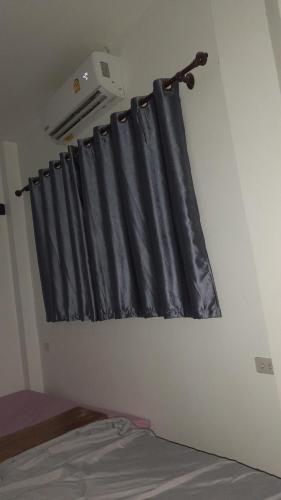 cortina negra en una habitación con cama en บ้านพัก en Ban Bang Pho