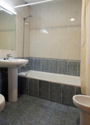 a bathroom with a sink and a tub and a toilet at Hotel Restaurante La Casilla in Cangas del Narcea