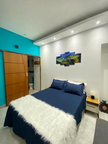 a bedroom with a blue bed with a white blanket at Casa de praia com vista para o mar in São Sebastião