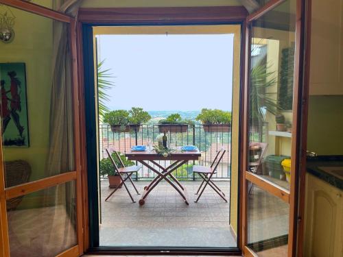 una porta scorrevole in vetro che conduce a un patio con tavolo di Ferienwohnung für 4 Personen ca 40 qm in Magliano in Toscana, Toskana Maremma a Magliano in Toscana