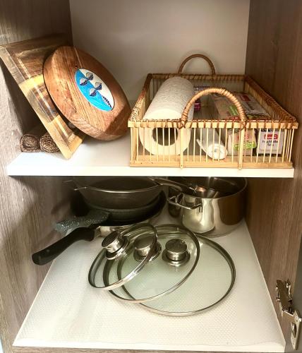 a kitchen shelf with a bird cage and a tea pot at Großes Apartment mit Terrasse und Garten in Oberhaching