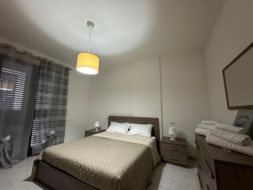 1 dormitorio con cama, espejo y lámpara en Amour Içi appartamenti e suite in centro en Mascalucia