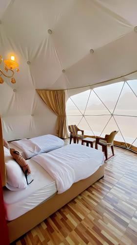 - une chambre avec un grand lit dans une tente dans l'établissement Wadi Rum palace, à Wadi Rum