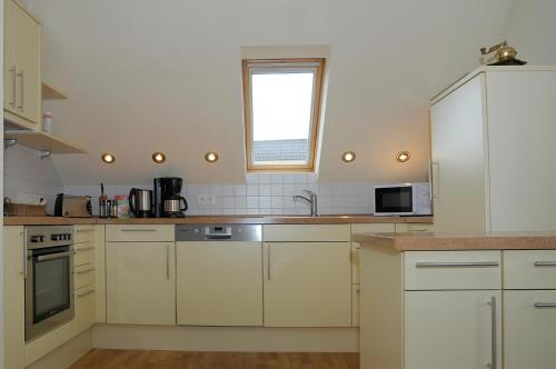 a kitchen with white cabinets and a window at Gabis-ferienwohnung in Munningen