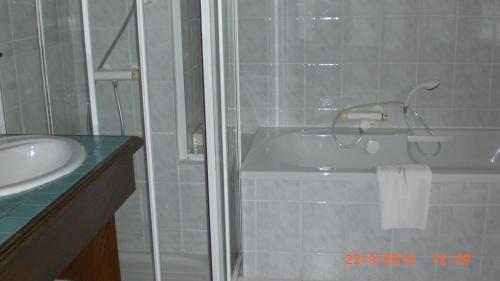 a bathroom with a bath tub and a sink at Auberge De L'Atre in Quarré-les-Tombes