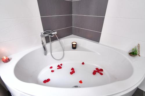 eine weiße Badewanne mit roten Blumen darin in der Unterkunft Ici on est à Laiz in Laiz