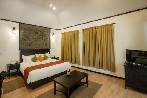 a hotel room with a bed and a television at The Hive, Wayanad in Wayanad