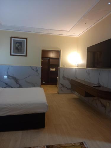 拉斯海瑪的住宿－Holiday Homes，配有一张床和一台平面电视的酒店客房