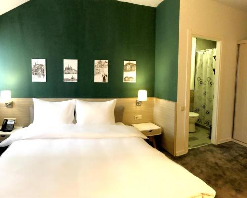 een slaapkamer met een groot bed en een groene muur bij Hotel In City in Jerevan