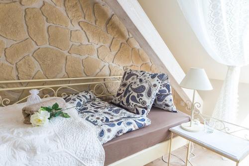 a bed with blue and white pillows and a table at Penzion Na Palubě in Jeseník