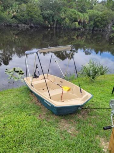 a small boat sitting on the grass next to a river at steve and cori's tropical king suite 2 in North Port