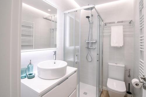 ein weißes Badezimmer mit Waschbecken und Dusche in der Unterkunft Apartamentos Casalarreina in Casalarreina