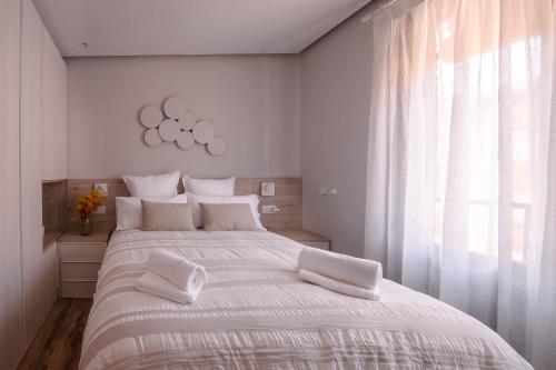 1 dormitorio blanco con 1 cama blanca grande con almohadas blancas en Apartamentos Casalarreina, en Casalarreina
