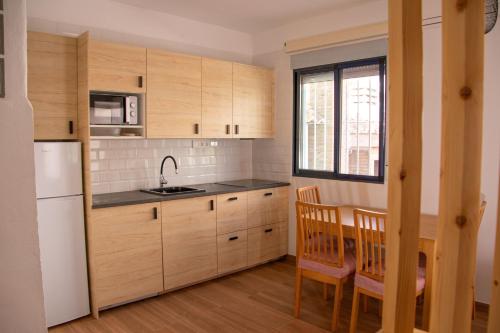 デニアにあるLa sirenitaのキッチン(木製キャビネット、テーブル、椅子付)