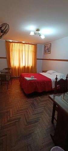 sypialnia z łóżkiem z czerwonym kocem w obiekcie HOTEL LAS GARDENIAS w mieście Trujillo