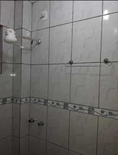 a bathroom with a shower with a glass door at Pousada Econômica in Uberlândia