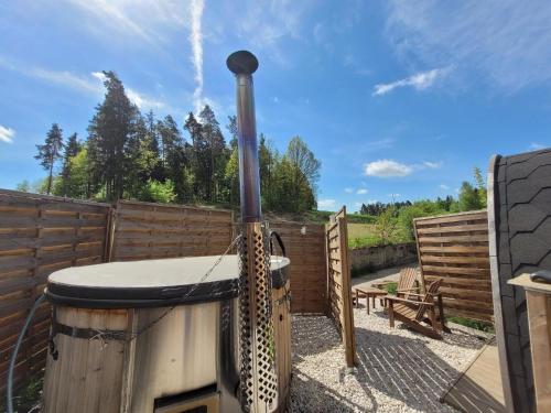 a hot tub in a backyard with a wooden fence at Romantisches Holz-Iglu Optional mit Hotpot mit Whirlpoolfunktion und LED Unterwasserbeleuchtung in Neuhaus an der Eger
