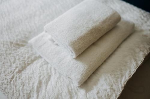 une pile de serviettes blanches assises au-dessus d'un lit dans l'établissement Jenapartments for7 Boxspring & Smart TV & Waschmaschine, à Iéna