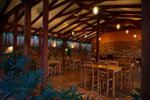 een restaurant met tafels en stoelen en een bakstenen muur bij Sereno Pool Villa Chikmagalur in Chikmagalūr