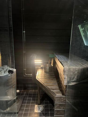 ein Badezimmer mit einem Holztisch und einer Dusche in der Unterkunft Mökki luonnon keskellä. in Tervola