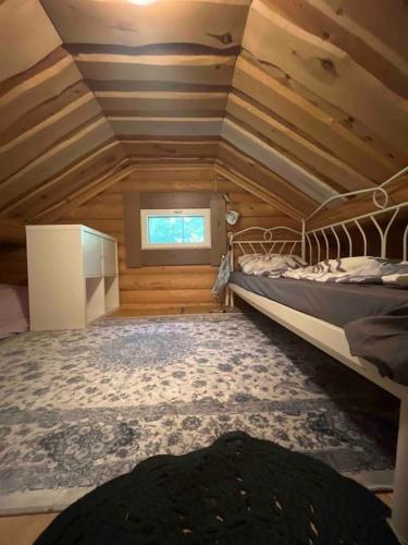 Schlafzimmer mit einem Bett und einem Fenster in der Unterkunft Mökki luonnon keskellä. in Tervola