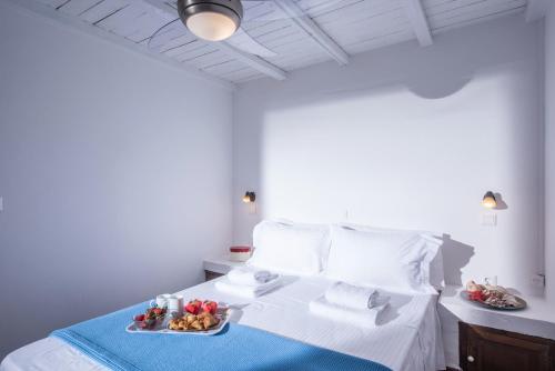 ein weißes Bett mit zwei Teller Essen drauf in der Unterkunft Little Seaside Villa in Hersonissos in Hersonissos