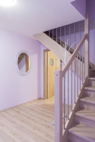 a hallway with a staircase with a mirror and a door at Penzion Na Palubě in Jeseník