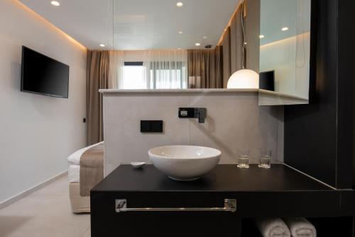 ein Badezimmer mit einem Spülbecken auf der Theke in der Unterkunft Alexandrion Appartements Down Town in Sarti