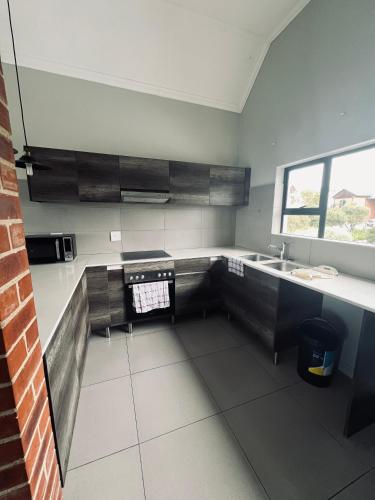 uma cozinha com um lavatório e uma bancada em Carlswald Apartments em Midrand
