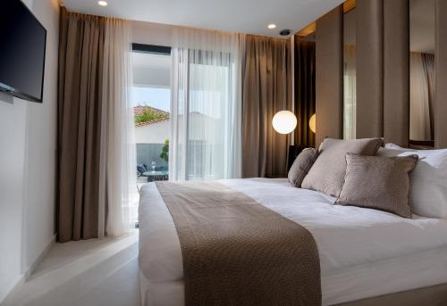 a bedroom with a large bed with a large window at Alexandrion Appartements Down Town in Sarti