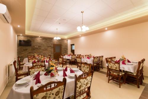 a dining room with white tables and chairs at Kentaur Lovaspanzió in Hódmezővásárhely