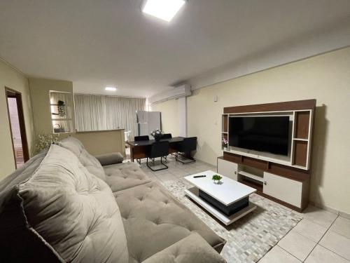 een woonkamer met een bank en een flatscreen-tv bij Aquarius Alugueis in Goiânia