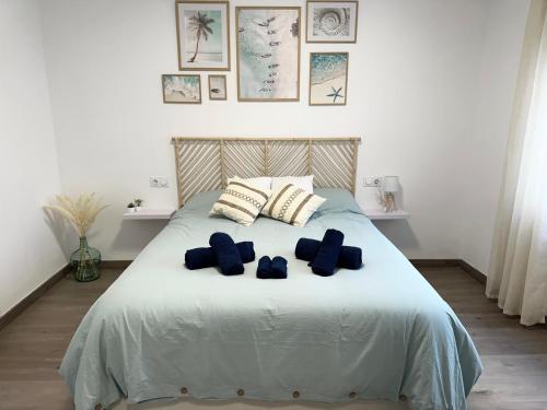 a bedroom with a bed with blue pillows on it at Bonita Planta baja con patio en 1ª línea de playa in Puerto de Sagunto
