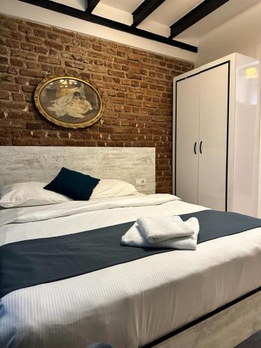 ein Schlafzimmer mit einem großen Bett und einer Ziegelwand in der Unterkunft VOLGAİSTANBUL in Istanbul