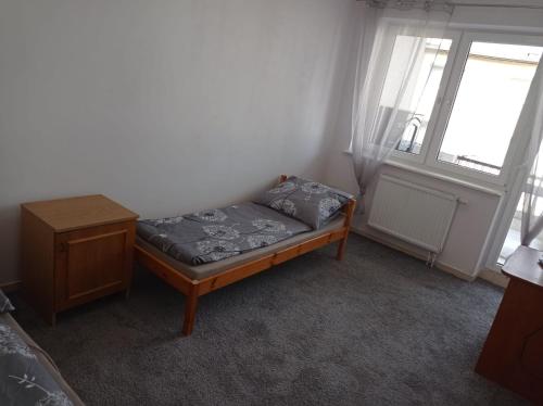 een klein bed in een kamer met een raam bij Gdańsk tanie noclegi nr 4 1-2 osobowy z łazienką na korytarzu in Gdańsk