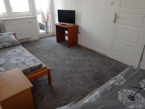 een kamer met een bed, een tv en een deur bij Gdańsk tanie noclegi nr 4 1-2 osobowy z łazienką na korytarzu in Gdańsk