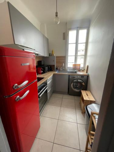 a kitchen with a red refrigerator and a sink at Profitez du calme de Courbevoie La Défense in Courbevoie