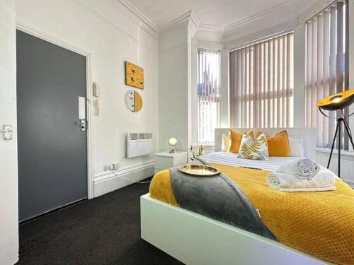 ein Schlafzimmer mit einem großen Bett und einer gelben Decke in der Unterkunft Tranquil Haven Studio Escape in Vibrant Birmingham in Birmingham