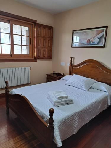 1 dormitorio con 1 cama grande con marco de madera en Hostal - Restaurante Casa Cuña, en Tebra